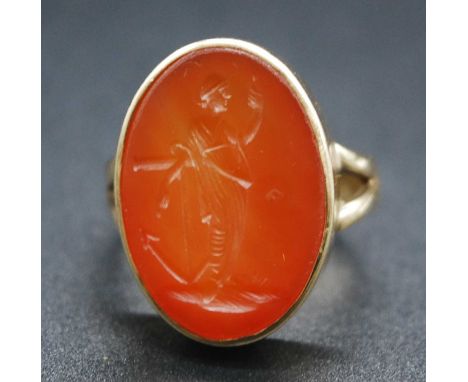 A Victorian 9ct gold carnelian intaglio ring, the oval tablet engraved with the figural depiction of Hope leaning upon an anc