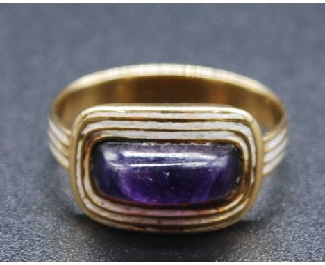 A late Georgian yellow metal and amethyst mourning ring, the raised cabochon amethyst measuring approx 10 x 5mm, within a ree