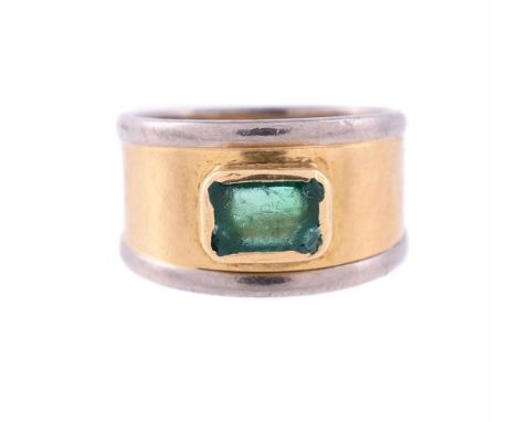 
	
		AN 18 CARAT GOLD AND EMERALD BAND RING 
		LONDON 1994
		The step cut emerald with canted corners set to a two colour tap