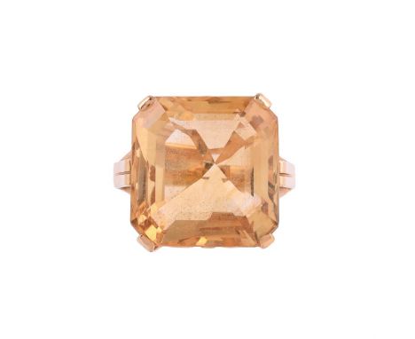 
	
		A MID 20TH CENTURY CITRINE DRESS RING
		The step cut citrine with canted corners in a scrolled gold coloured setting, to