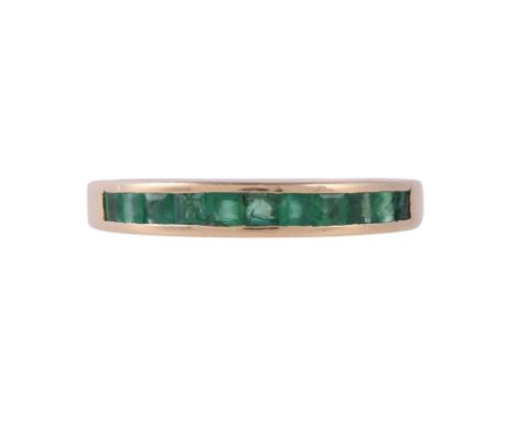 
	
		AN EMERALD HALF ETERNITY RING
		The channel set row of step cut emeralds in a gold coloured setting, stamped 750 18k, wi