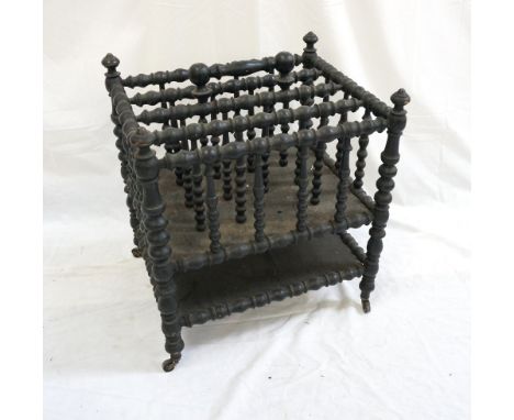 VICTORIAN EBONISED CANTERBURY 
with four bobbin turned divisions and similar carrying handle, with a tier below, standing on 