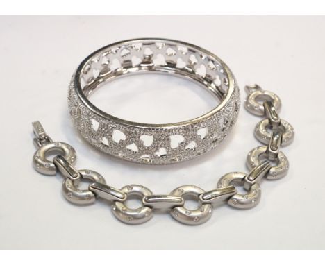 SWAROVSKI CRYSTAL BANGLE
with pierced heart decoration, brand new with box; together with a Swarovski bracelet with crystal s