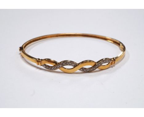 DIAMOND SET BANGLE
in nine carat gold, the diamonds in pierced twist setting