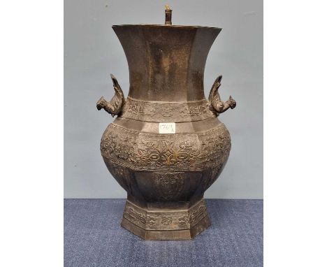A Chinese bronze hexagonal section baluster vase as a lamp, the body cast with daodieh below the bird handles.   H 42cms.