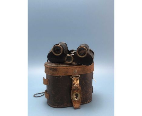 A leather cased pair of Leitz binoculars with leather mounted barrels, bearing a label stating they were taken from a Japanes