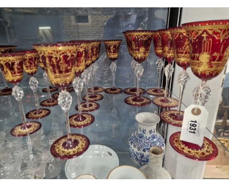 A suite of Venetian ruby glass drinking glasses with clear teared glass stems and gilt with 18th C. figures promenading on a 