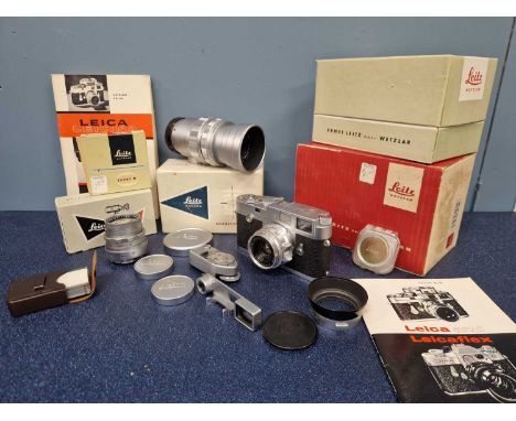 A Leica camera M2-942320, a Leitz Wetzlar lens 1:2/35, another 1:2/50 and a third 1:2/90, a flash unit, leather cases, bookle