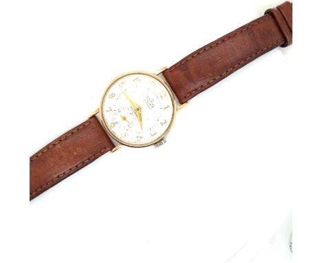 A vintage 9ct hallmarked gold Smiths De Luxe manual wound gents presentation wrist watch on a brown leather strap. Engraved t