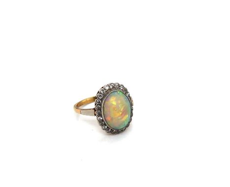 A vintage opal and diamond ring. A cluster of 24 round diamonds surrounds the oval cabochon opal. Opal measurements in settin