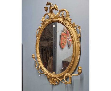 A 19th C. oval girandole mirror, the gilt frame crested by pierced foliage scrolls, the base with two candle branches.   118 