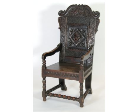 LATE SEVENTEENTH CENTURY AND LATER CARVED OAK WAINSCOT CHAIR, the scroll top rail carved with a pair of fire breathing serpen