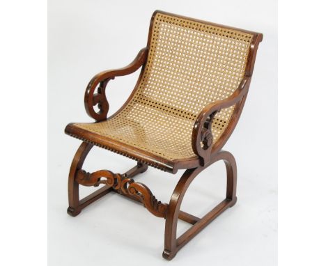 EARLY TWENTIETH CENTURY CARVED MAHOGANY AND CANED SMALL OPEN ARMCHAIR, the one piece scooped back and seat, flanked by a pair