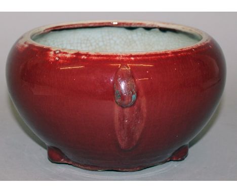 A CHINESE SANG-DE-BOEUF PORCELAIN TRIPOD BEGGING BOWL, circa 1800, the sides applied with a streaked and crackled glaze, 8.3i