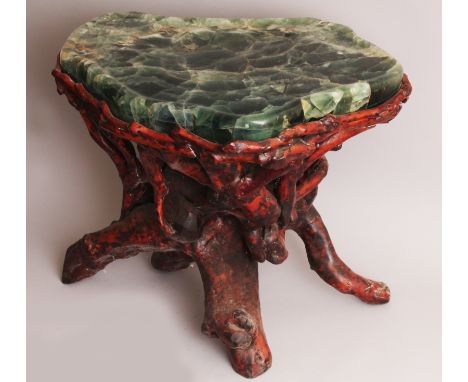 A CHINESE GREEN HARDSTONE AND ROOT WOOD TABLE, the stone with natural striations, the root wood stand stained red and black, 