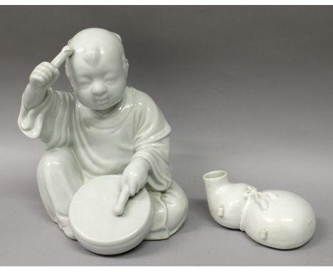 A GOOD 19TH/20TH CENTURY JAPANESE HIRADO WHITE GLAZED PORCELAIN FIGURE OF A BOY, seated and playing a drum, the base unglazed