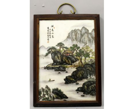 A CHINESE WOOD FRAMED PORCELAIN PLAQUE, decorated with calligraphy and a mountainous river landscape scene, the frame 15.5in 