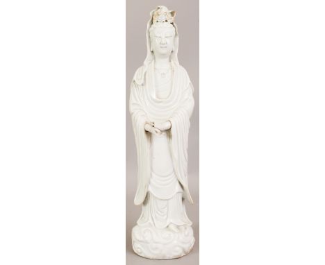 A LARGE CHINESE KANGXI PERIOD BLANC-DE-CHINE PORCELAIN FIGURE OF GUANYIN, circa 1700, standing in flowing robes on a cloud sc