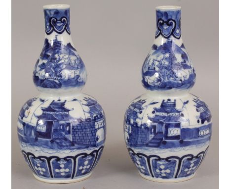 A GOOD PAIR OF 19TH CENTURY CHINESE BLUE & WHITE DOUBLE GOURD PORCELAIN VASES, each painted with a walled settlement in a mou