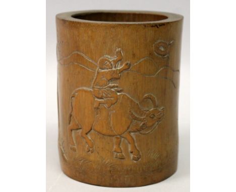 A 19TH/20TH CENTURY CHINESE BAMBOO BRUSHPOT, the side incised with calligraphy and carved in low relief with a boy seated on 