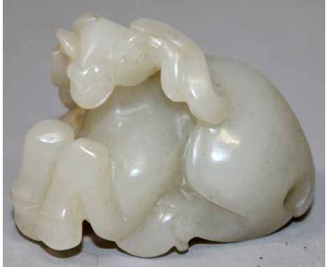 A CHINESE PALE CELADON JADE MODEL OF A SEATED RAM, 2.3in long & 1.75in high.