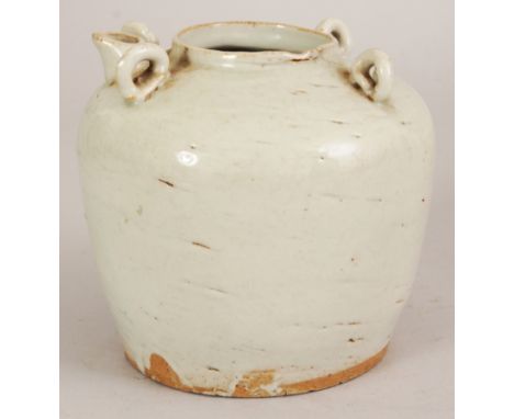 A CHINESE CREAM GLAZED CERAMIC EWER, possibly early, the shoulders moulded with lug handles and a spout, the base unglazed, 4
