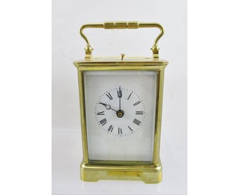 A LATE VICTORIAN BRASS FRAMED CARRIAGE CLOCK having bevelled glass panels, white enamel dial with Roman numerals, 8-day repea