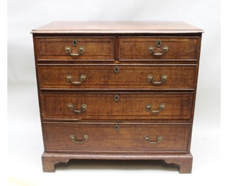 A GEORGE III OAK CHEST of two short over three long graduated drawers, mahogany cross-banded, decorative brass swan neck hand
