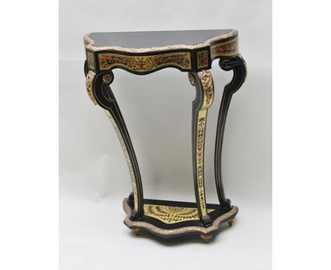 A CONTINENTAL BOULLE EFFECT EBONISED CONSOLE TABLE, with cast gilt metal mounts, the top of serpentine form, on tapering supp