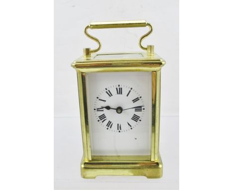 A 20TH CENTURY BRASS FRAMED CARRIAGE CLOCK having bevelled glass panels, French movement, the dial with Roman numerals, 11cm 