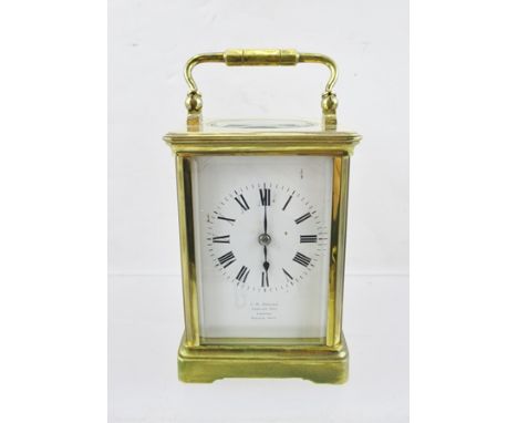 A LATE VICTORIAN BRASS FRAMED CARRIAGE CLOCK having bevelled glass panels, French made, the white enamel dial with Roman nume