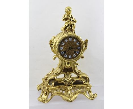 A LATE 19TH CENTURY ORMOLU FRENCH MANTEL CLOCK, the case of Rococo design, scrolls and acanthus leaves, mounted with a putti 