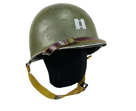 American M1 helmet with liner. On the front, a captain's rank insignia is painted, and on the back, a vertical stripe indicat