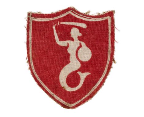 Shield-shaped badge made of red fabric, with a white border. In the center of the shield is a white mermaid holding a sabre a