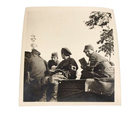 A photograph depicting women from the Polish Red Cross sanitary teams along with Polish Army soldiers sitting on a cart.Dimen