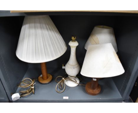 Three wooden lamps with shades, one made from a vintage bobbin along with a marble lamp base.