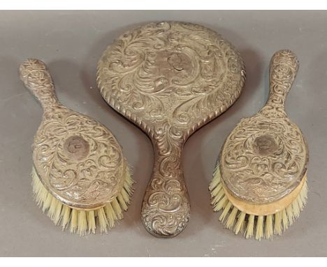 A Chester silver backed three piece dressing table set comprising two brushes and a hand mirror 
