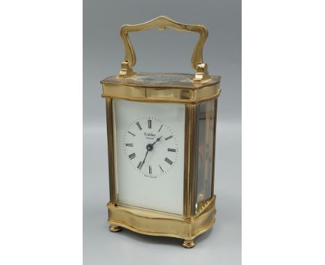 A French brass cased Carriage clock of serpentine form with lever escapement and carrying handle, 12cms tall