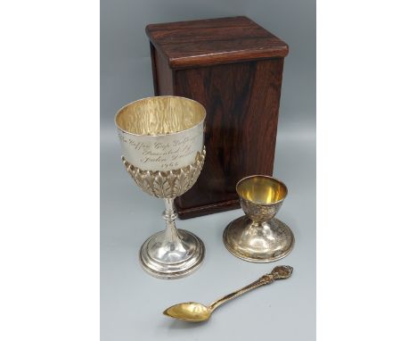 An Indian white metal trophy cup within Rosewood box, together with an 800 mark silver eggcup with spoon, 7ozs