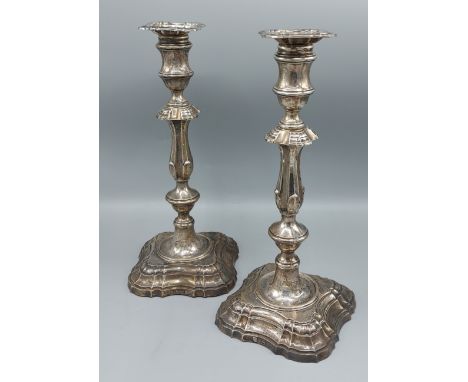 A pair of Edwardian silver candlesticks in Georgian style with shaped stepped bases, Sheffield 1909, makers Hamilton and Co. 