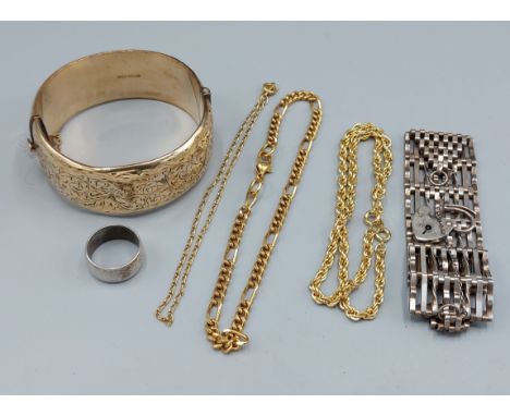 A gold plated bangle together with three gold plated chains, a silver gate bracelet and a wedding band