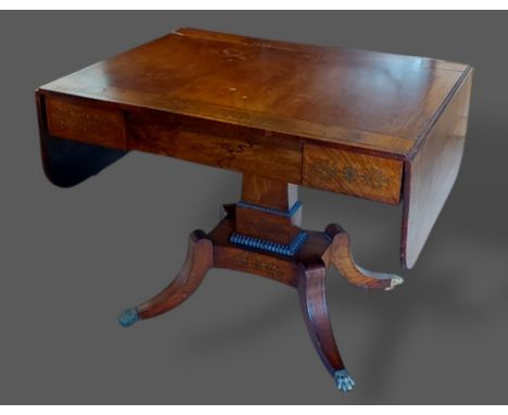 A Regency Rosewood and brass inlaid Sofa Table with a drop flap top and frieze drawer with rectangular column and out swept l