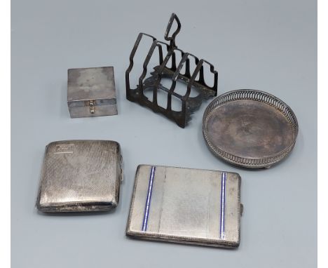 A Sheffield silver four division toast rack together with two silver cigarette cases, a London silver coaster and a London si