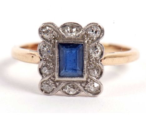 A sapphire and diamond ring, the central rectangular sapphie surrounded by small single cut diamonds, all set in white metal 