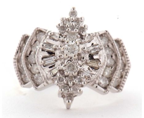 A 14ct diamond ring, the Odeonesque style ring set with round brilliant and baguette cut diamonds, with tapered shoulders and