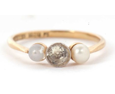 An 18ct three stone ring, set with a central white stone with a cultured pearl to either side, with plain band stamped 18ct, 