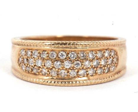 A 9ct diamond ring, the 8mm wide band set with small round diamonds, with rope twist border continuing down the tapered shoul