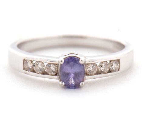A 9ct tanzanite and diamond ring, the central oval tanzanite in a four claw mount, with diamond set shoulders, stamped 375 wi