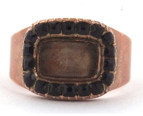 An early 19th century memorial ring, the rectangular keepsake panel (empty) surrounded by black glass, with closed back engra