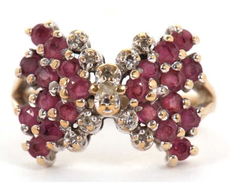 A 9ct ruby and diamond bow ring, the bow set with rubies and diamond detailing to centre, split shoulders and plain band hall